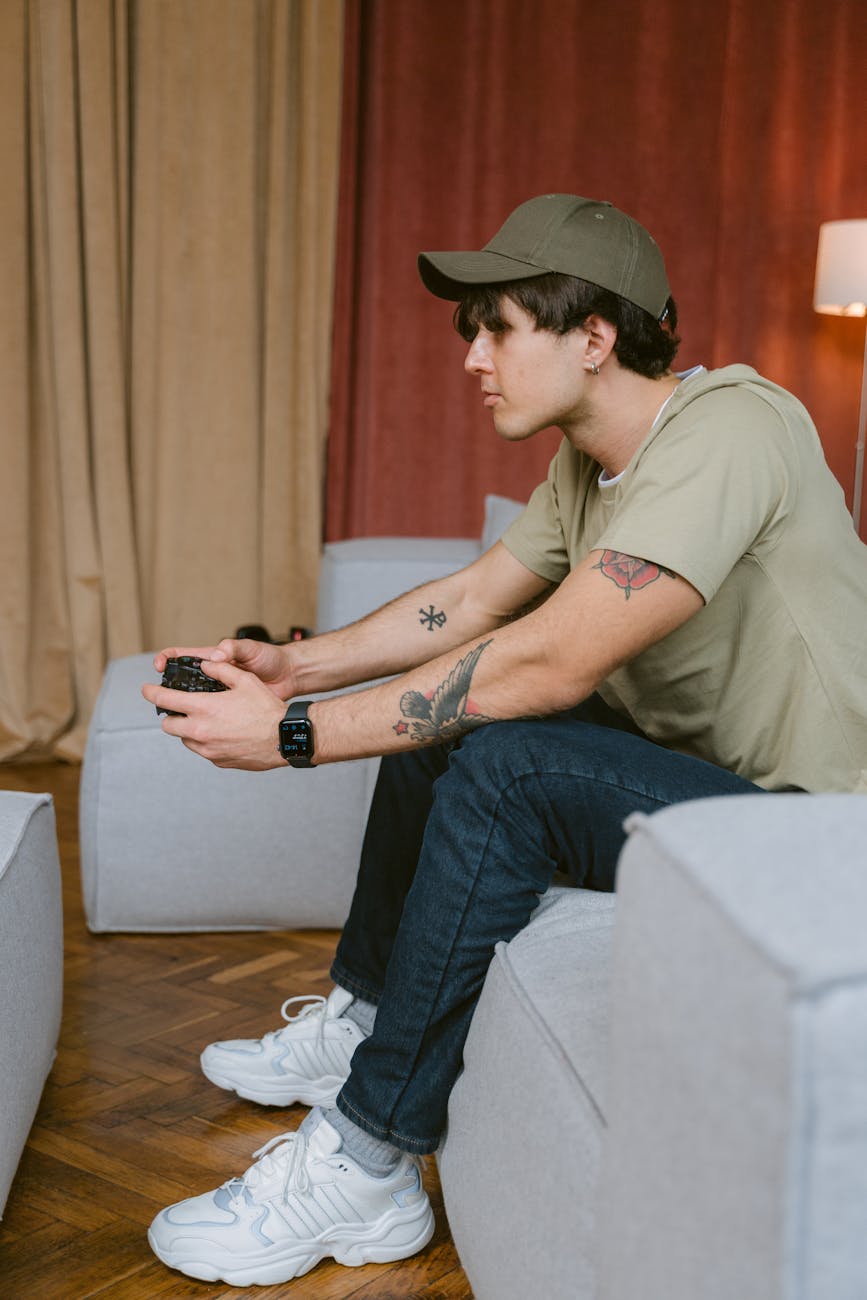 a man in brown shirt playing games using a controller while sitting on a couch